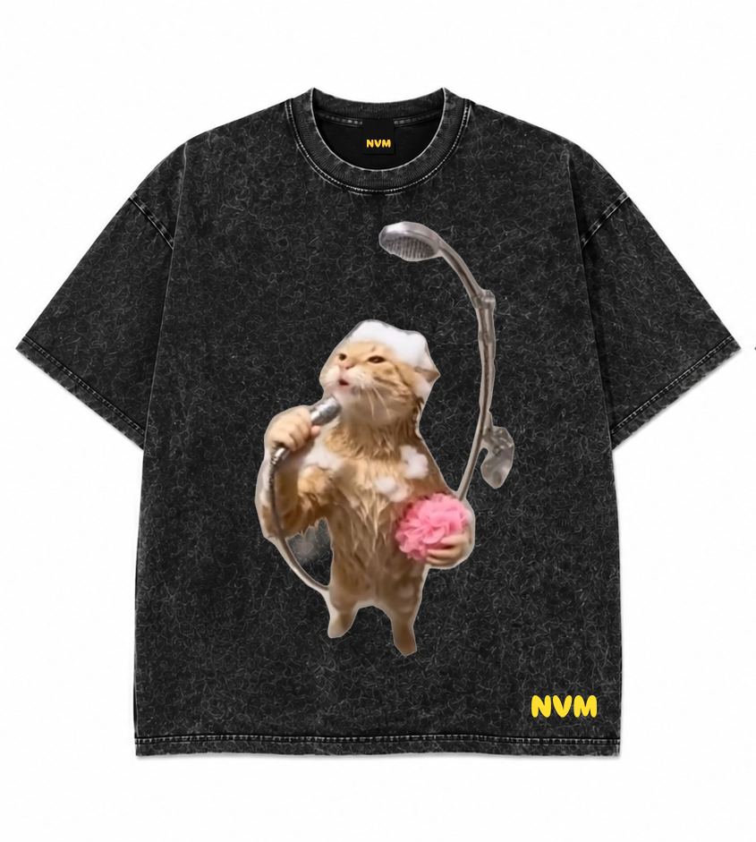 A black acid-wash short-sleeve t-shirt shown from both the front and back. The front features a graphic of a cat wearing headphones and holding a pink brain, with 'NVM' printed in yellow near the bottom hem.