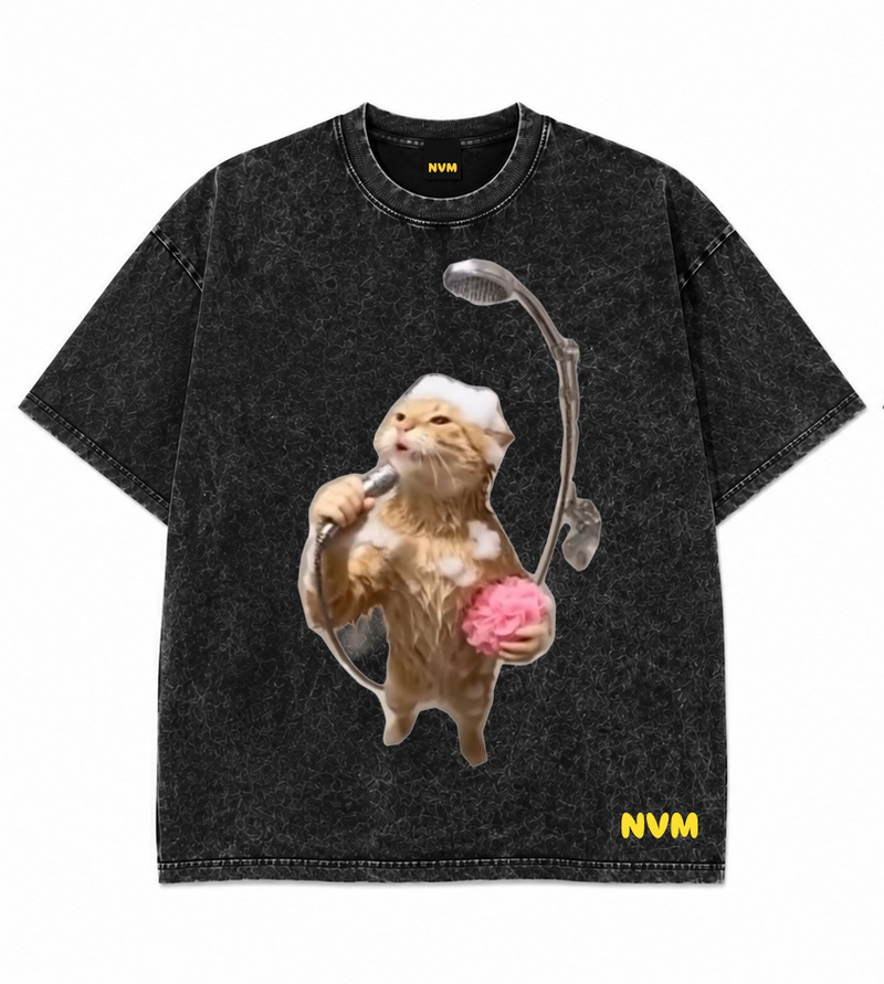 A black acid-wash short-sleeve t-shirt shown from both the front and back. The front features a graphic of a cat wearing headphones and holding a pink brain, with 'NVM' printed in yellow near the bottom hem.
