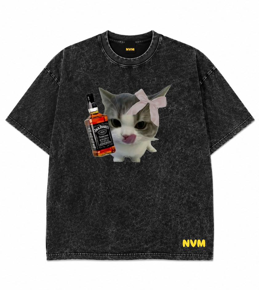 A black acid-wash t-shirt shown from both front and back views. The front features a graphic of a cat holding a Jack Daniel's bottle with a pink bow, and 'NVM' printed in yellow on the bottom right.